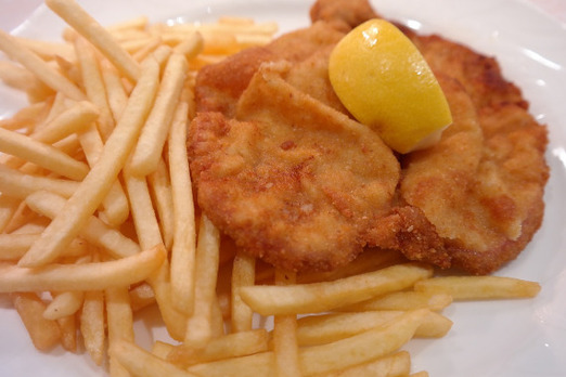 Goldbraun paniertes Schweineschnitzel mit Beilage frisch serviert bei Da Piero in Graz